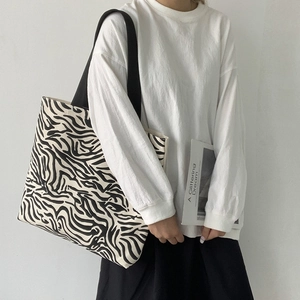 Gros plan d'un sac cabas en toile à motif zèbre avec bandoulière noire