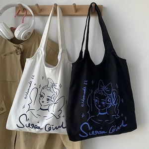 Dettaglio di borse tote in tela bianche e nere con illustrazioni di ragazze