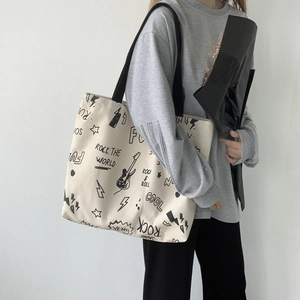 Détail de graffiti style rock sur un sac cabas en toile avec motifs de guitares