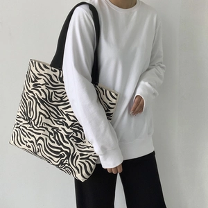 Détail du sac cabas en toile zébrée montrant la grande capacité et la large bandoulière noire
