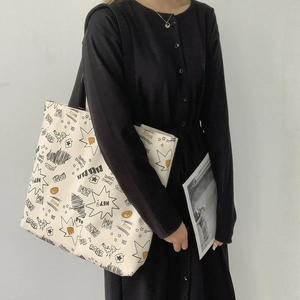 Detail view of large canvas tote bag with street style graffiti and matching pouch