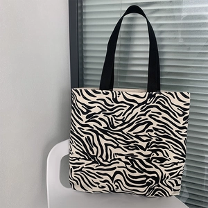 Gros plan détaillé d'un sac cabas en toile zébrée sur une chaise blanche