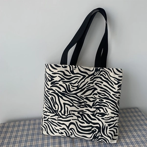 Détail du sac cabas en toile à motif zèbre avec poignées noires pour usage quotidien