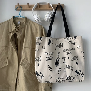 Détail du sac cabas en toile avec imprimé Rock The World et anses noires sur crochet