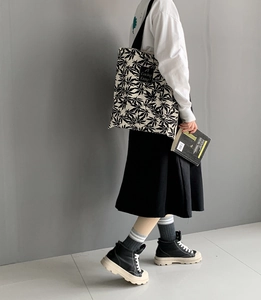 Détail du sac en toile avec motifs de feuilles d'érable noires et étiquette tissée