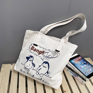 Detail of white canvas tote bag with blue cartoon penguin print and large capacity
