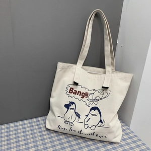 Close-up of large canvas tote bag with blue cartoon penguin and Bang text design