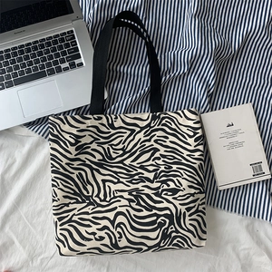 Sac cabas en toile zébré avec ordinateur pour montrer la grande capacité de rangement
