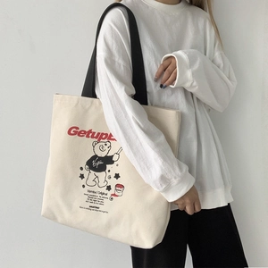 Detail of canvas tote bag showing red Getup lettering and cute cartoon bear print