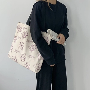 Detail of off-white canvas tote bag featuring cute purple bear print and large capacity