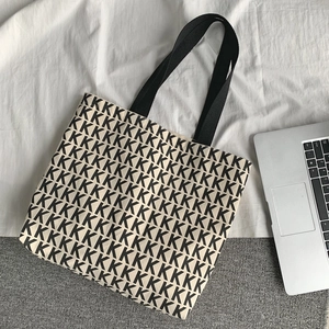 Dettaglio della grande borsa tote in tela con stampa K nera e tracolle resistenti