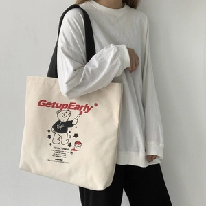 Detail of canvas tote bag featuring red GetupEarly text and cute bear illustration