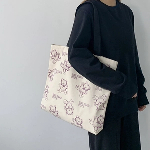 Detail of canvas tote bag featuring a cute purple bear print and hey bear cute text