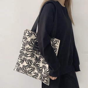 Détail d'un sac cabas en toile avec motif feuille de chanvre et écusson Lucky Day