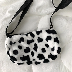Detailed close-up of plush leopard cow print crossbody bag with soft texture and zip