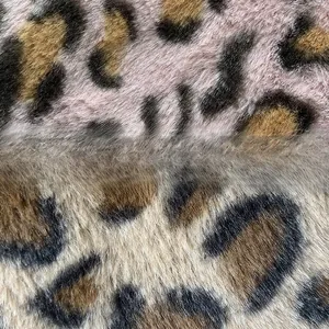 Close-up of soft faux fur fabric texture featuring pink and brown leopard print patterns