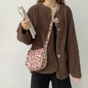 Detail of pink leopard print plush crossbody bag paired with a brown fleece cardigan