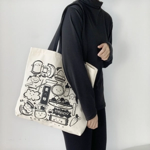 Detail of white canvas tote bag featuring minimalist cartoon food line art and Japanese text