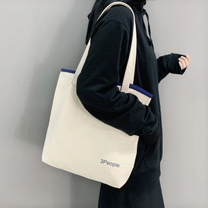 Dettaglio della borsa tote in tela con bordo blu e logo 3People su tessuto crema