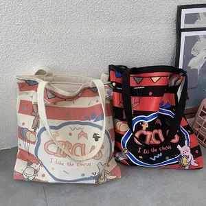 Detail of thickened canvas tote bags featuring circus illustrations and red stripes