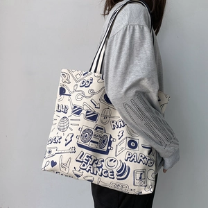 Japanese style canvas tote bag with blue graffiti print and striped shoulder strap