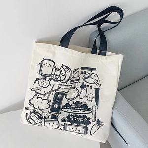 Detail of canvas tote bag showing cute food illustrations and blue fabric handles