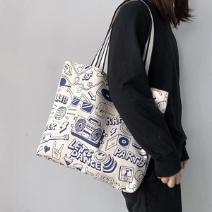 Minimalist canvas tote bag with retro blue graffiti print and striped woven shoulder strap