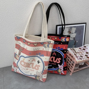 Detail of canvas tote bags with circus rabbit illustration and striped handles