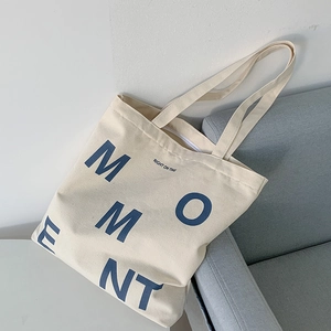 Close-up of MOMENT letter print on high-density cotton canvas tote bag with reinforced handles