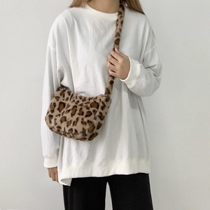 Detail view of the soft plush leopard print crossbody bag with a wide shoulder strap