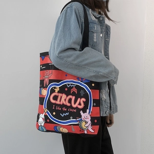 Detail of red and black striped canvas tote bag with circus cartoon prints and black straps