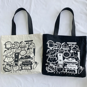 Close-up of canvas tote bags with cartoon food illustrations and Japanese typography