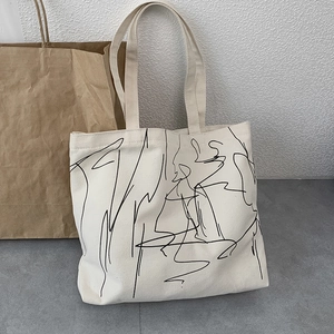 Minimalist canvas tote bag with black abstract line art for daily commuting and school