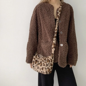 Detail of trendy leopard print plush crossbody bag paired with a brown fleece cardigan