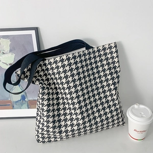 Klassische Canvas-Tragetasche mit Hahnentrittmuster in einem stilvollen Lifestyle-Setting