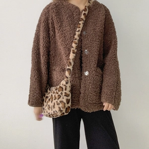 Detail of plush leopard print crossbody bag paired with brown sherpa fleece jacket