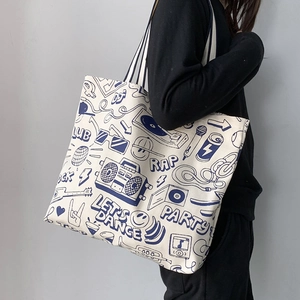 Detail of canvas tote bag with retro hip-hop graffiti prints and blue shoulder straps