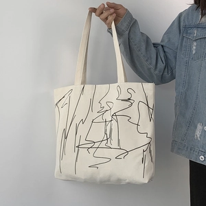 Close-up of minimalist canvas tote bag with black abstract line art and sturdy shoulder straps