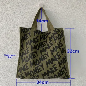 Detail showing army green canvas tote with black letter print and size measurements