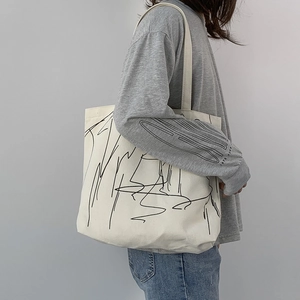Detail of canvas tote bag with abstract line art print worn by a person in a minimalist style