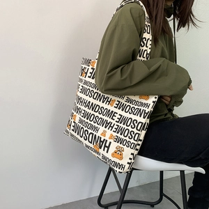 Detail of canvas tote bag showing handsome text and cute bear pattern on shoulder