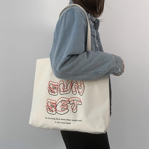 Detail view of white canvas tote bag with red and black Sunset artistic printing