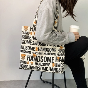 Detail of canvas tote bag featuring handsome lettering and a cartoon bear print