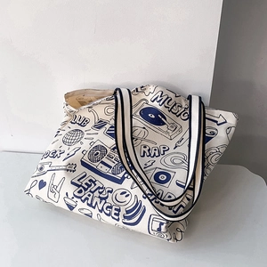 Detail of canvas tote bag with navy blue music-themed graffiti and sturdy woven handles