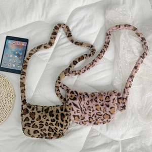 Close-up of fluffy leopard print plush crossbody bags in brown and pink faux fur