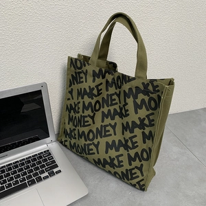 Detail of olive green canvas tote bag with Make Money script print and sturdy handles