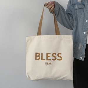 Borsa tote in tela crema minimalista con manici marroni e scritte BLESS per scuola