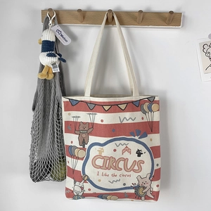 Close-up of canvas tote bag with red stripes and circus animal illustrations