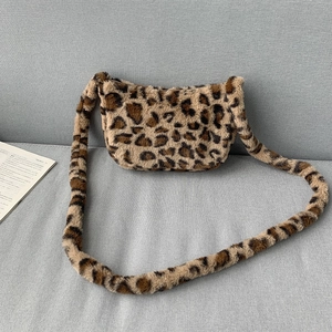 Flat lay of leopard print plush crossbody bag with wide fuzzy shoulder strap