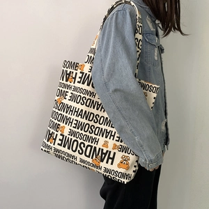 Detail of canvas shoulder bag with cartoon bear print and black handsome text lettering